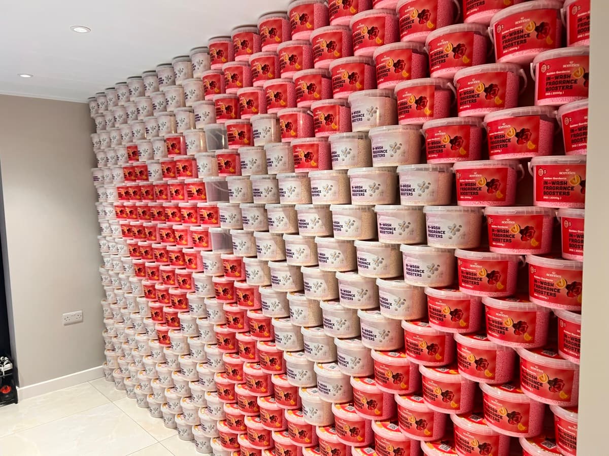 A wall of stacked Scentl in-wash fragrance booster tubs